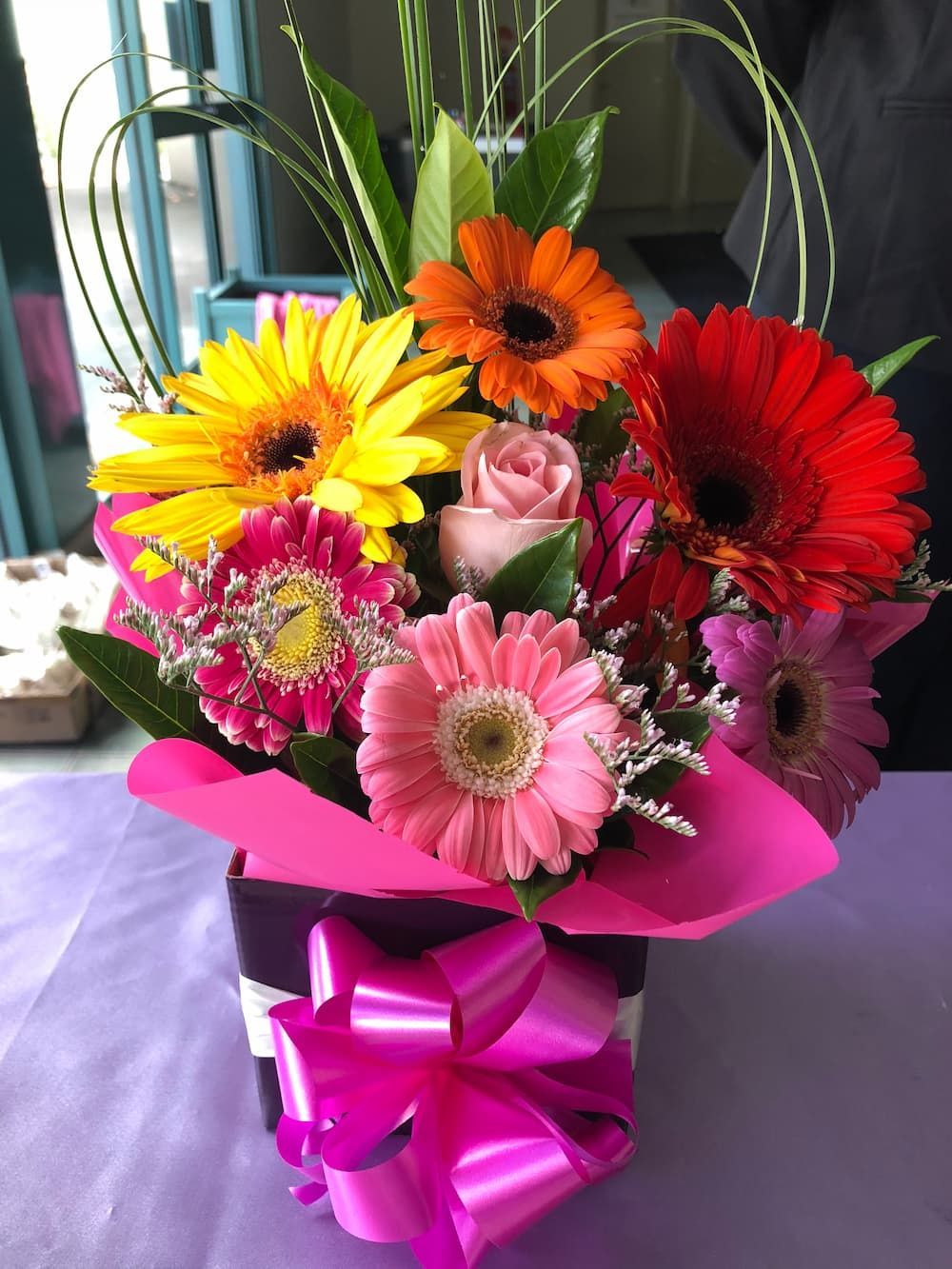 A bouquet of flowers in a box with a pink bow - Funeral Services in Upper Coomera, QLD