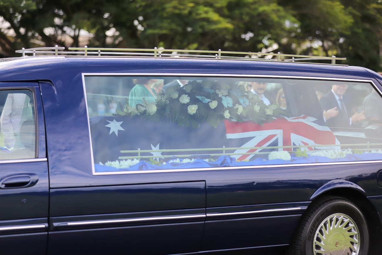 A blue coffin with a british flag on top of it - Funeral Services in Upper Coomera, QLD