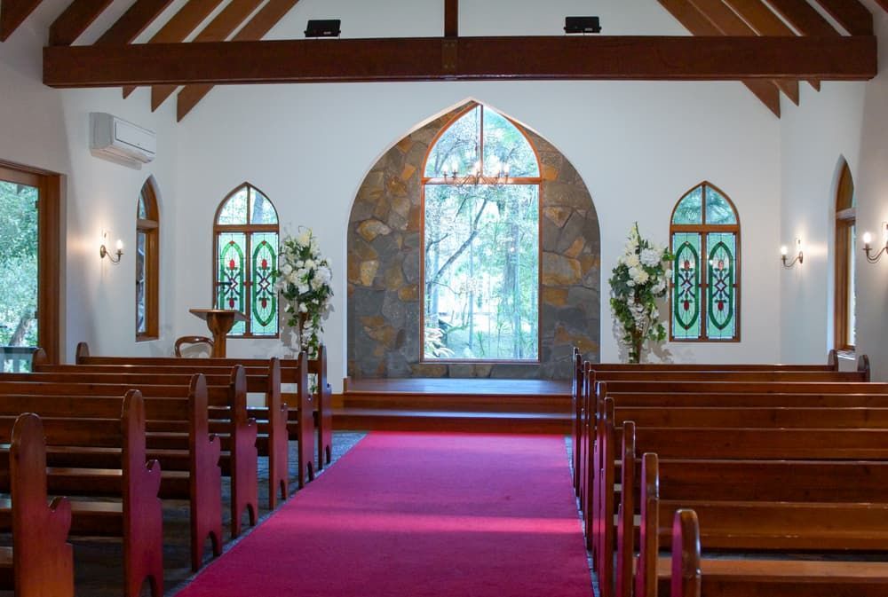 A church with a red carpet and stained glass windows - Funeral Services in Upper Coomera, QLD