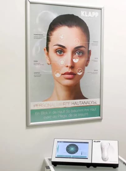 Bild-mit-Gesicht-einer-Frau-an-weisser-Wand-ueber-Geraet-zur-Hautanalyse