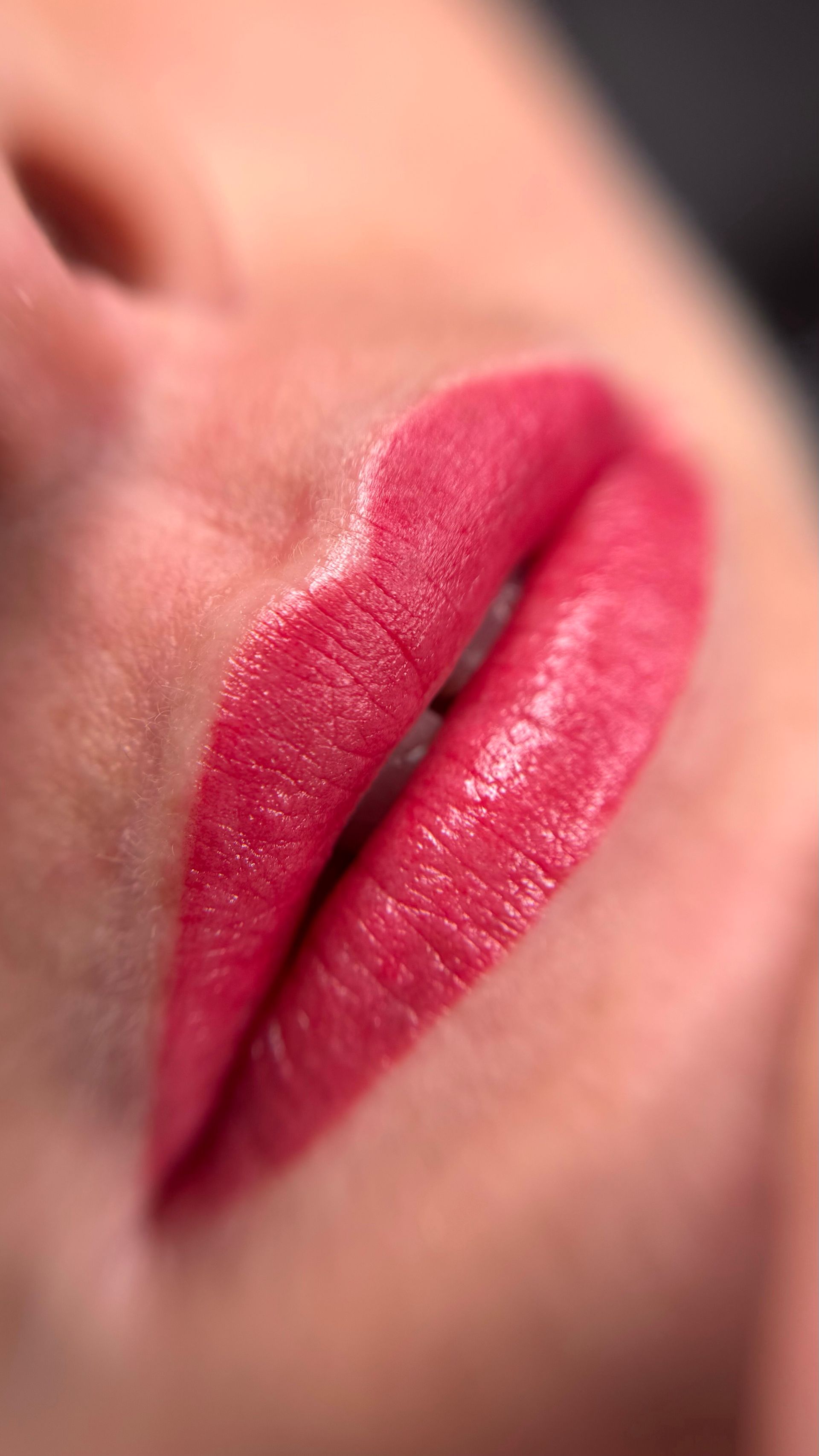 Eine Nahaufnahme der Lippen einer Frau mit rosa Lippenstift.