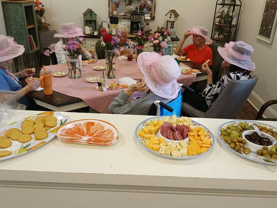 A group of people are sitting around a table eating food.