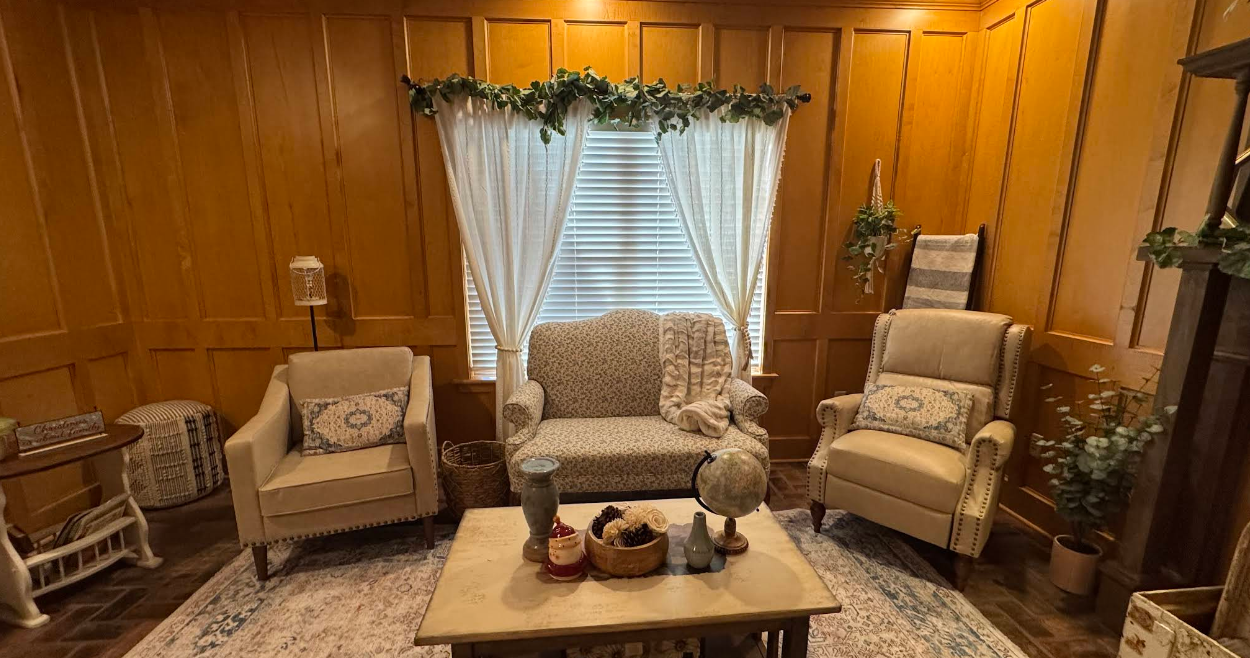 A living room with a couch , chairs , and a coffee table.