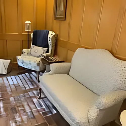 A living room with a couch a chair and a lamp