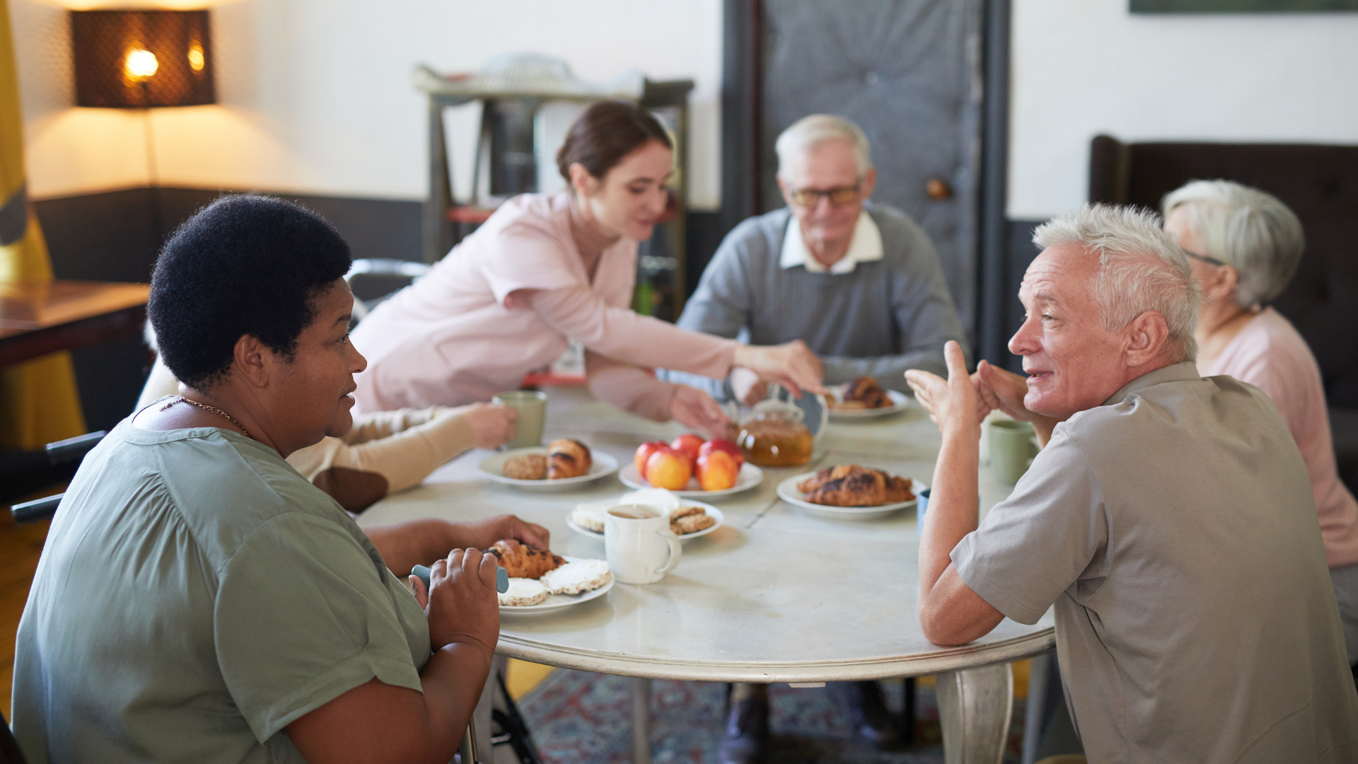 A group of people are sitting around a table eating food.