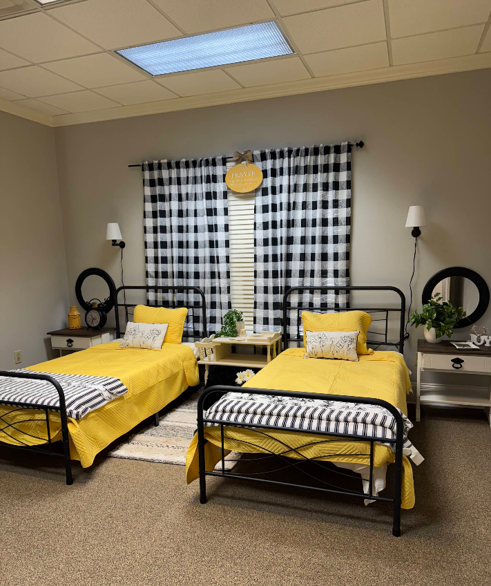 A bedroom with two beds and a checkered curtain