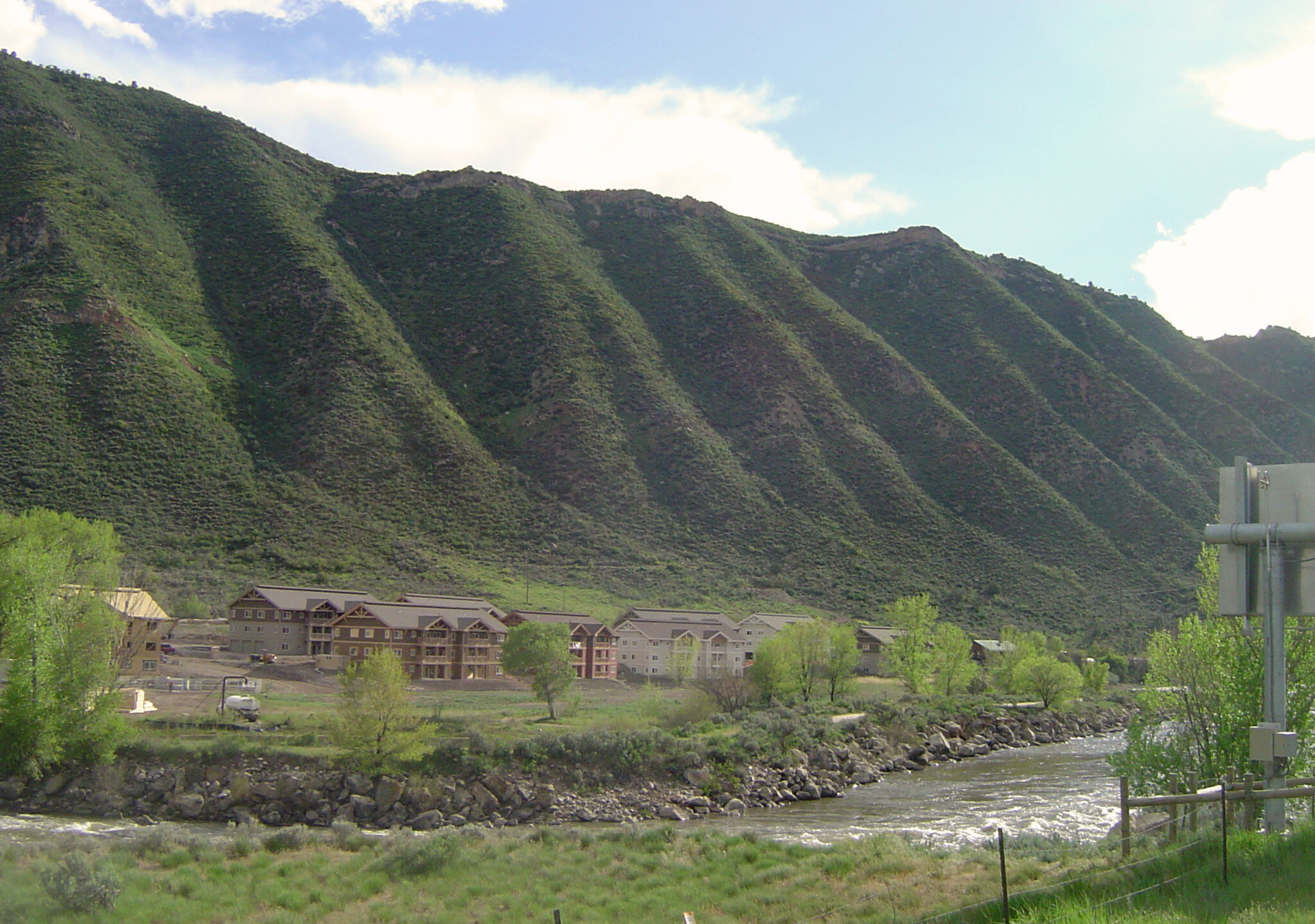 A river flowing through a valley with mountains in the background.