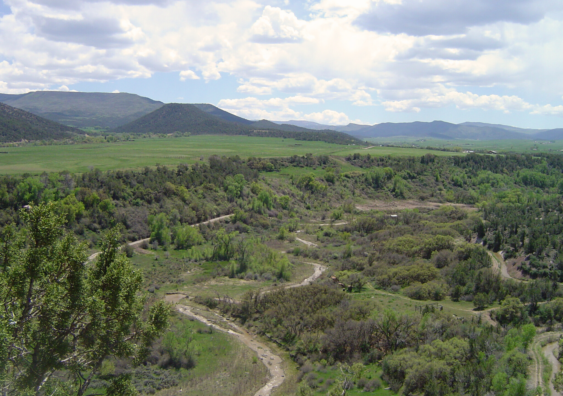 A view of a valley with mountains in the background.