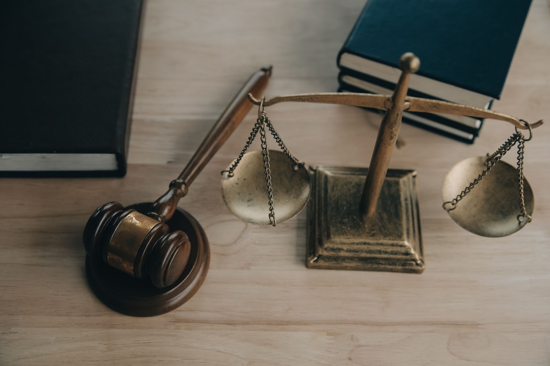A judge 's gavel and scales of justice are on a wooden table.