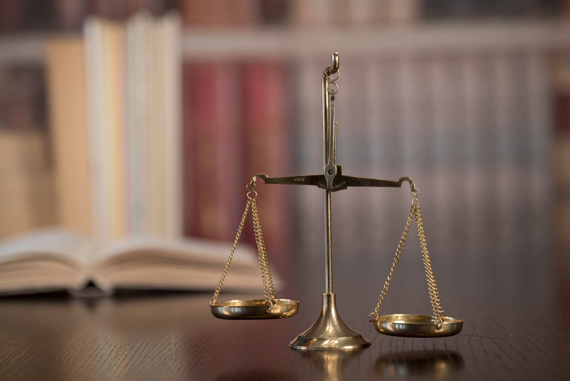 A scale of justice is sitting on a wooden table.