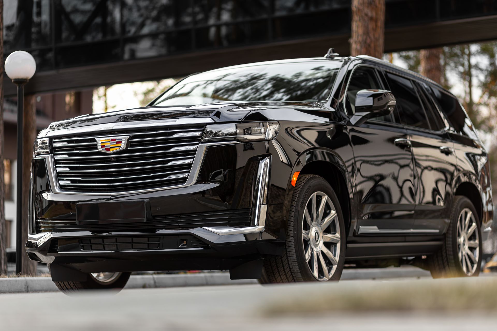 Black Cadillac Escalade SUV parked outside a building.