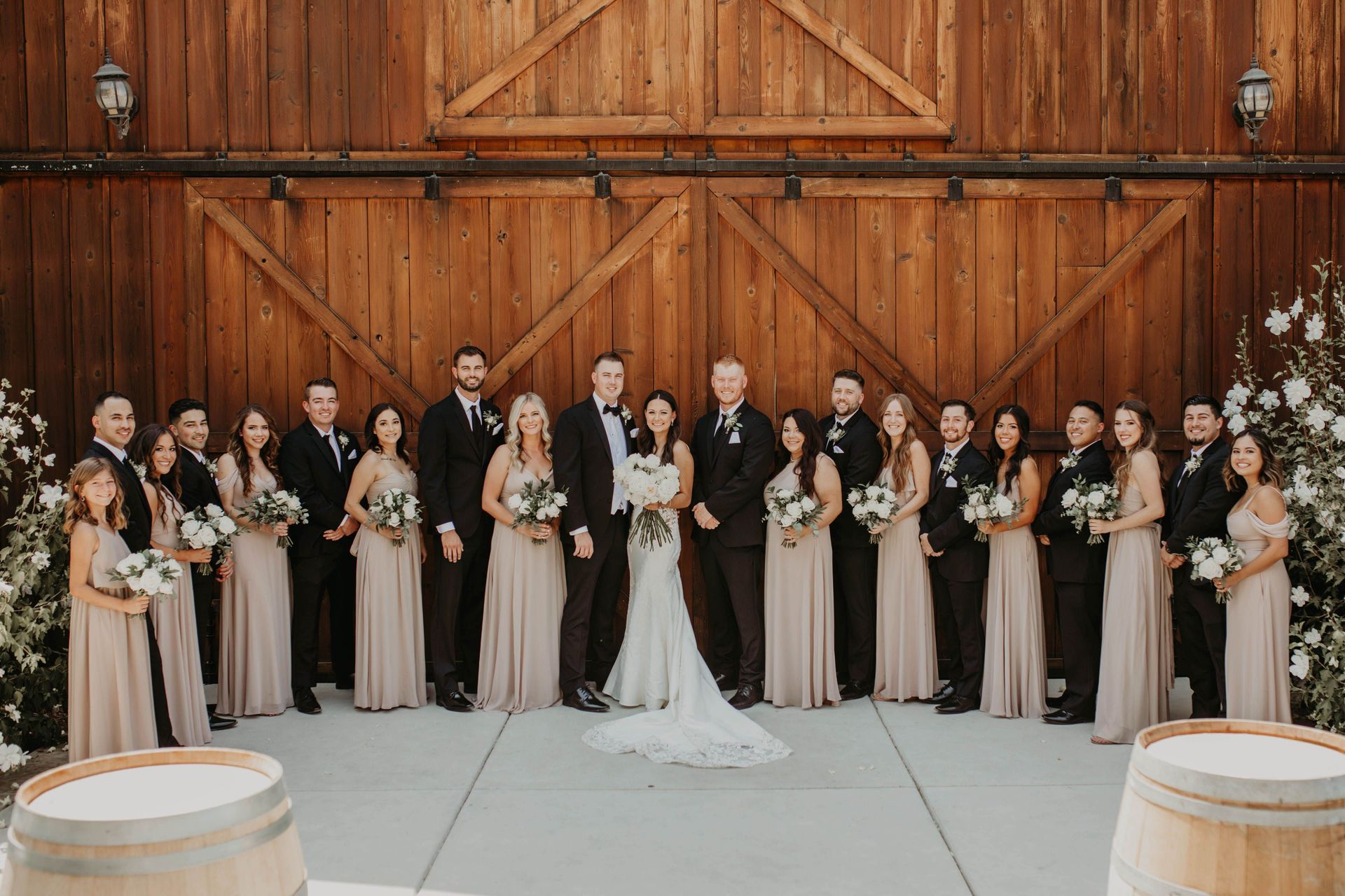 neutral wedding party in front of barn