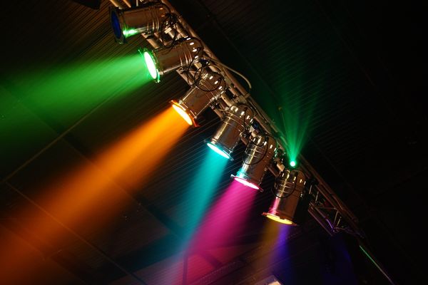 Multi-colored spotlights on the ceiling of a venue.