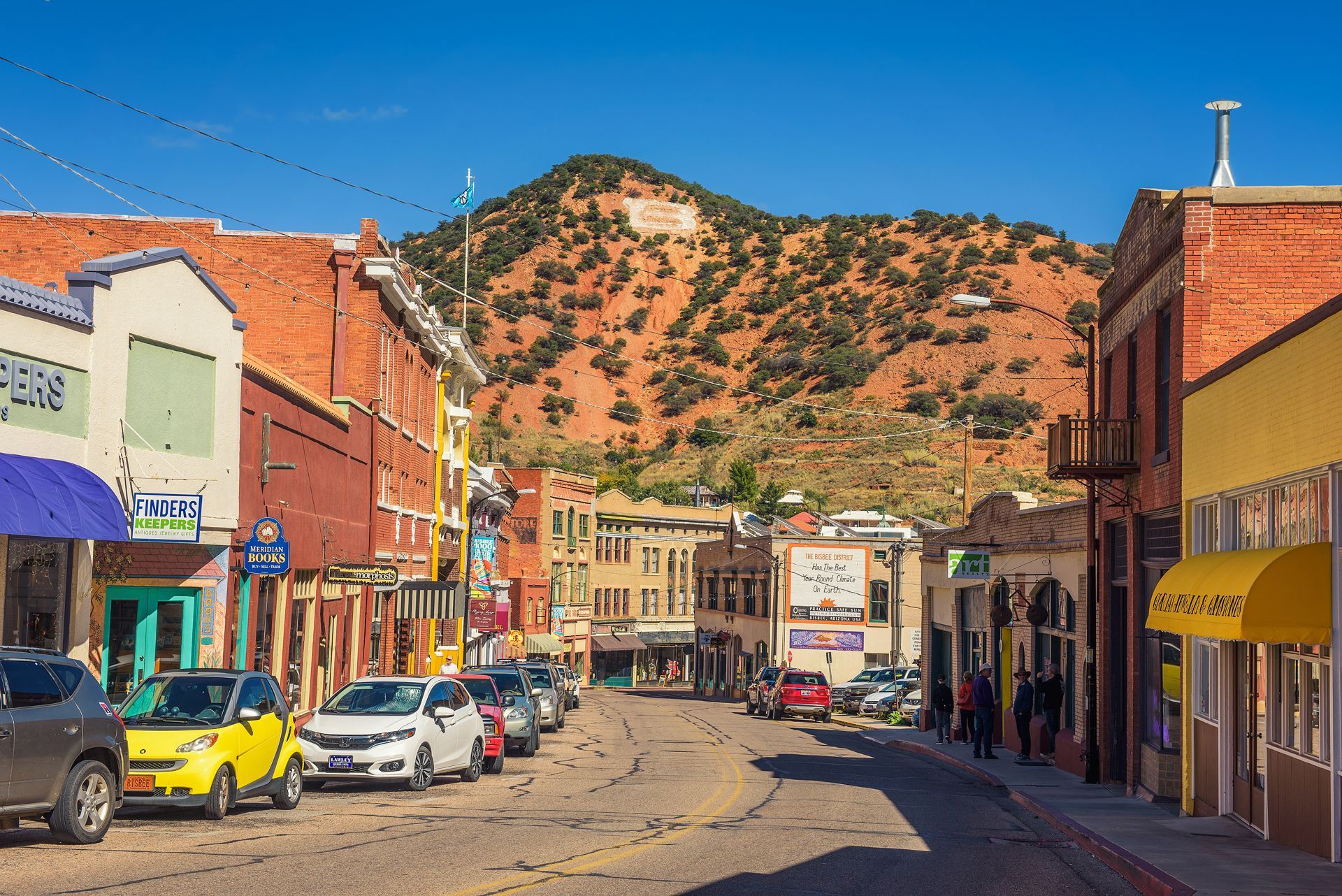 A Row of Cars Are Parked on the Side of a Street in a Small Town