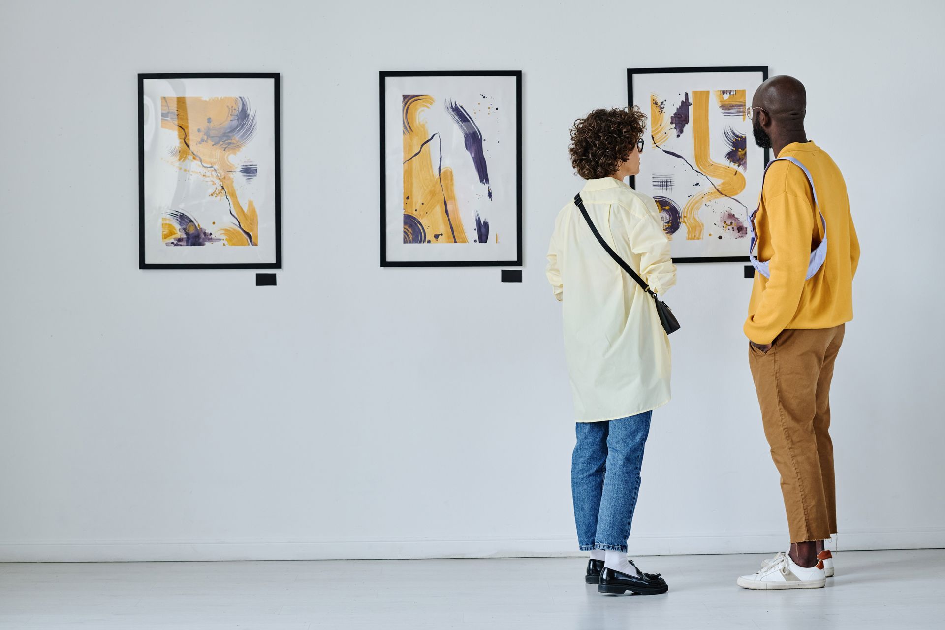 A Man and a Woman Are Looking at Paintings in a Museum