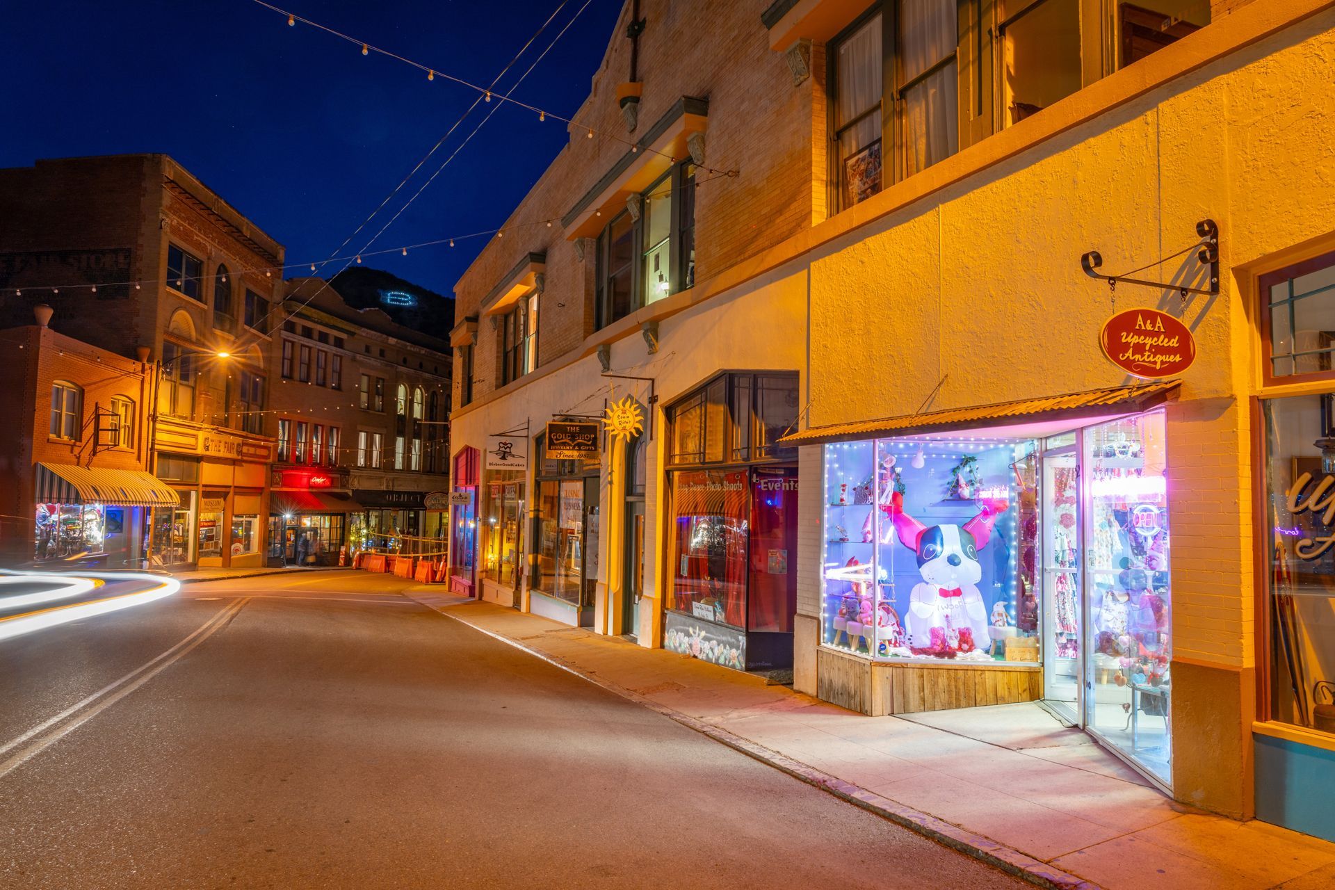 A City Street at Night With a Store Front Lit Up