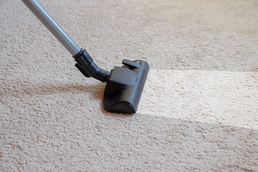 A Person Using Vacuum Cleaner For Floor Cleaning — Big Red Carpet & Property Maintenance In Bowen, QLD