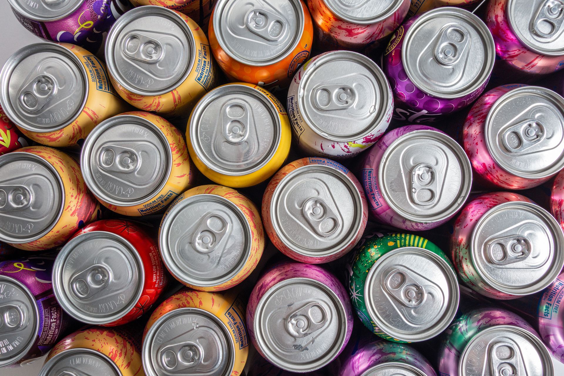 Overhead view of colorful beverage cans, arranged closely together.