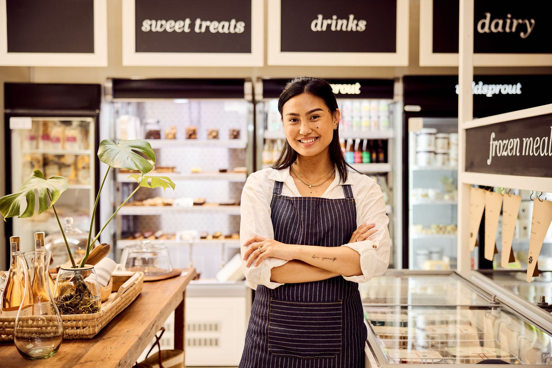 Four people smile, looking at items in a vending machine in a brightly lit store.