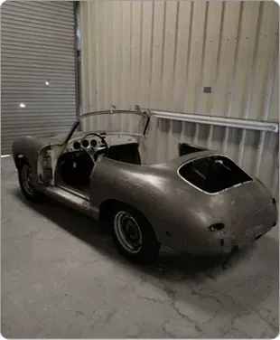 A car is parked in a garage with the door open.