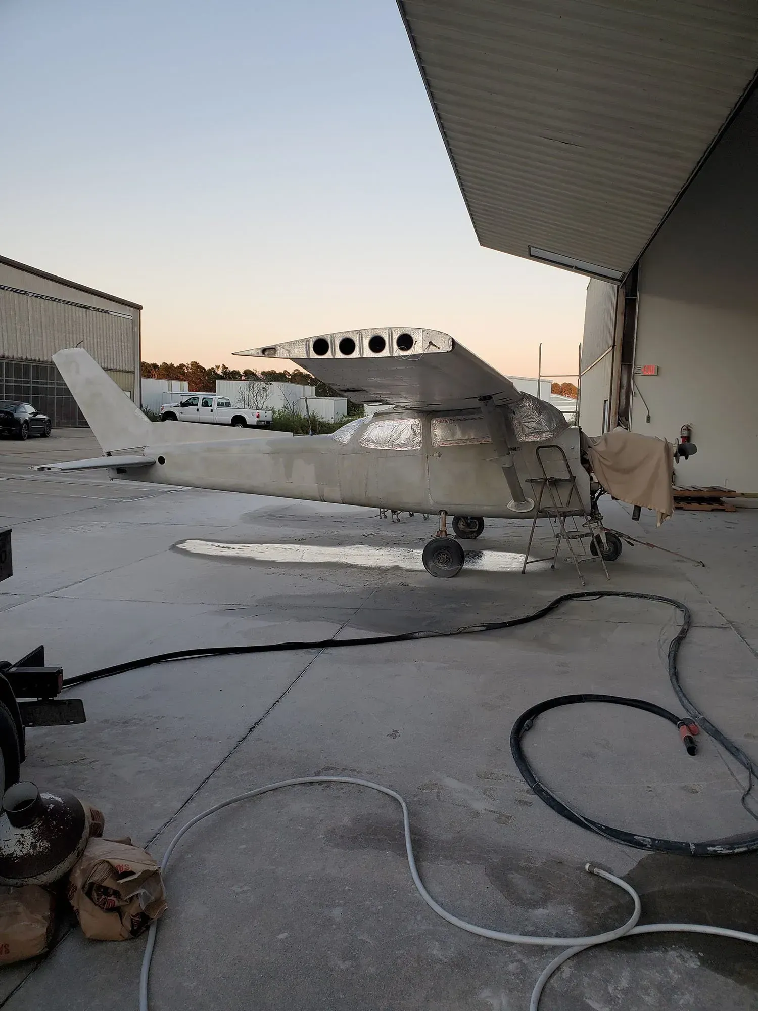 A small plane is parked outside of a hangar.
