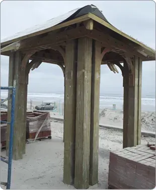 A wooden gazebo is being built on the beach.