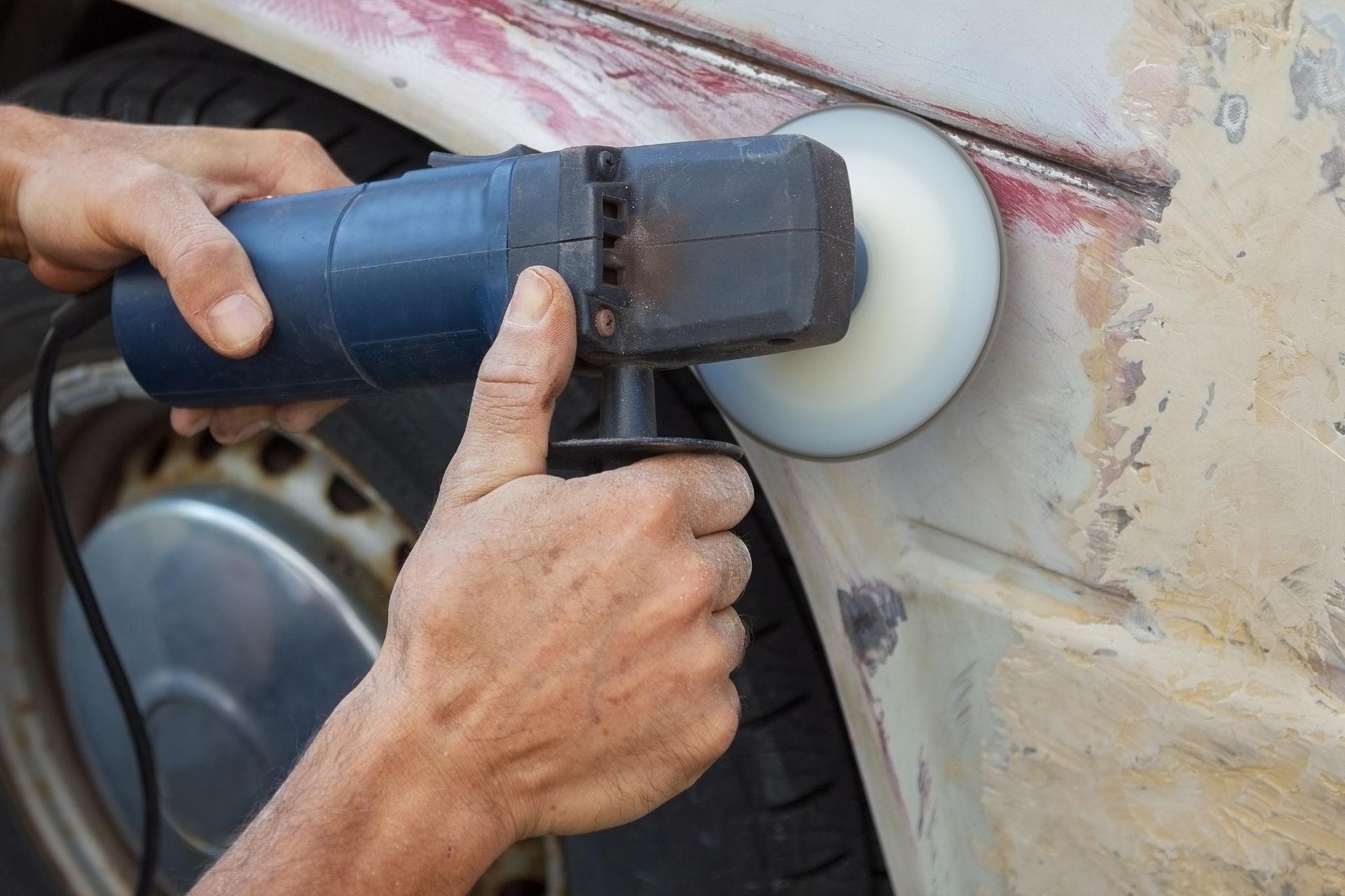A person is polishing a car with a machine.
