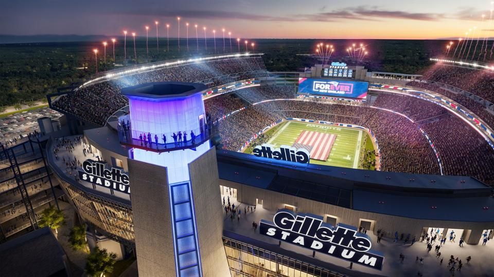 Aerial view of Gillette Stadium at night, lit up with fireworks and fans.
