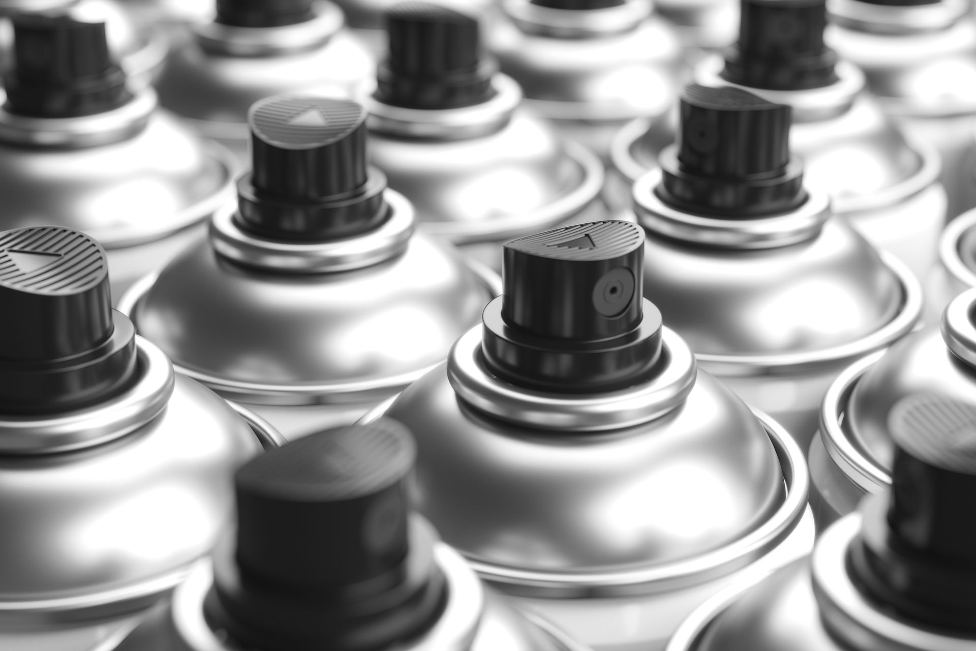 A bunch of spray cans are stacked on top of each other.