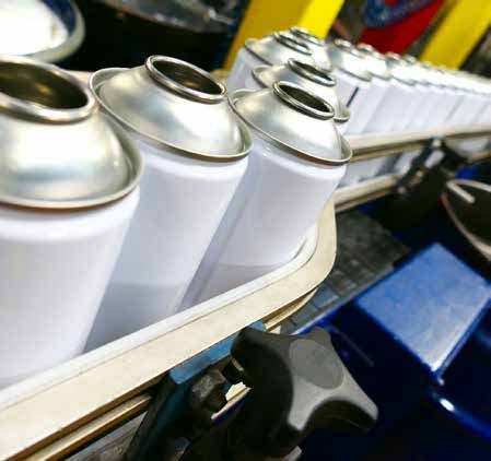 A conveyor belt filled with cans of spray paint