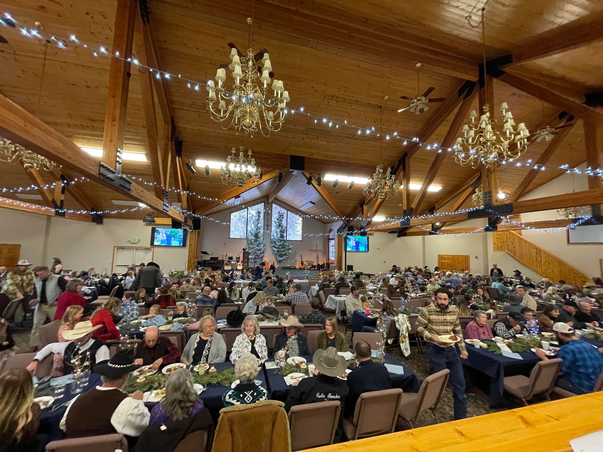 A large group of people are sitting at tables in a large room.