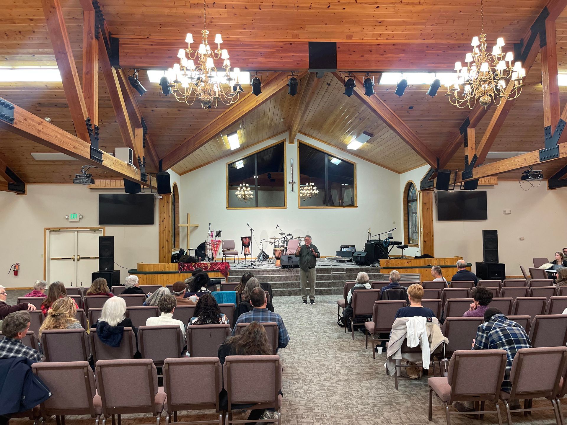 A group of people are sitting in rows of chairs in a church.