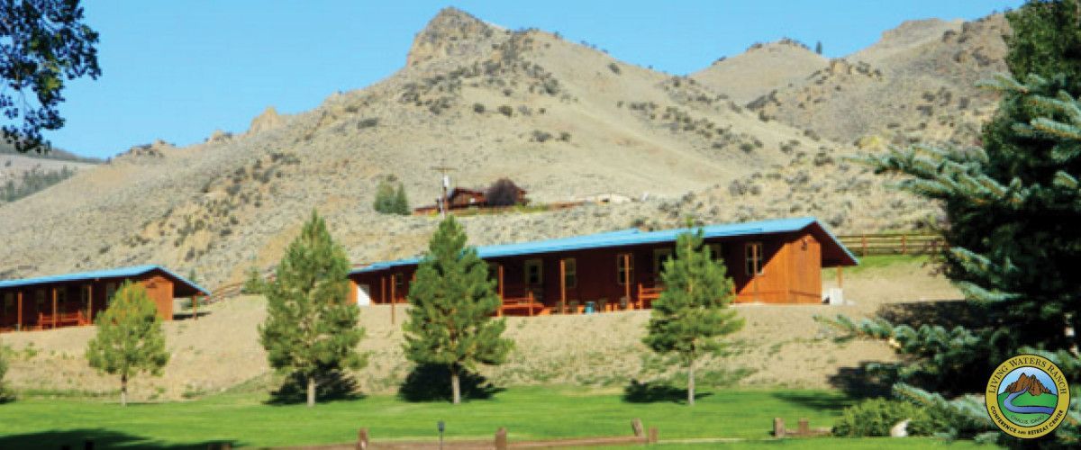 A row of wooden buildings with mountains in the background