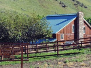 A house with a blue roof and a fence around it