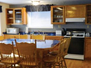 A kitchen with a table and chairs and a stove
