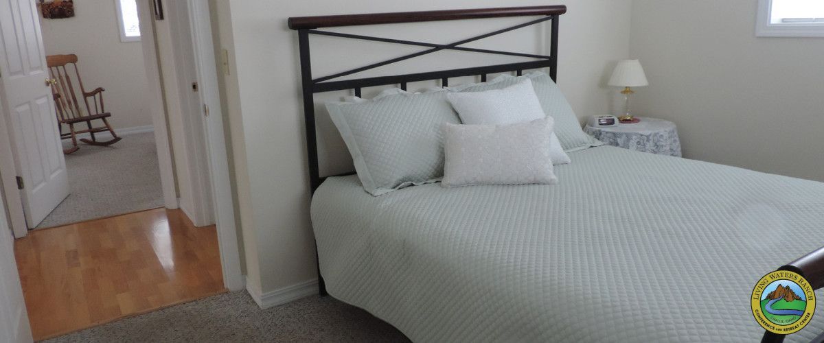 A bedroom with a bed and a rocking chair.