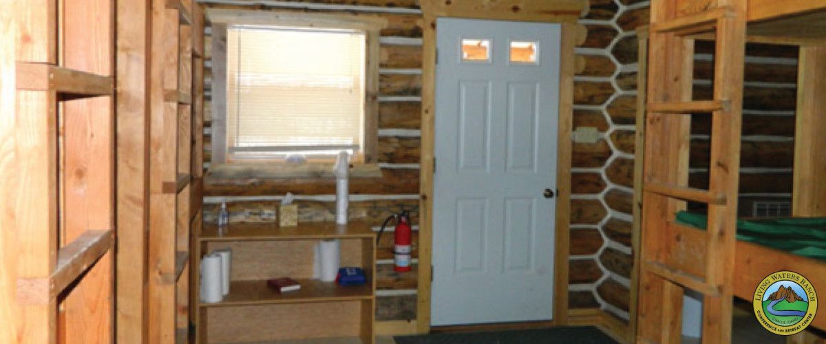 A log cabin with bunk beds and a white door