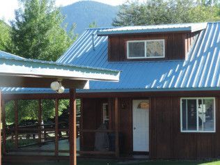 A house with a blue roof and a screened in porch