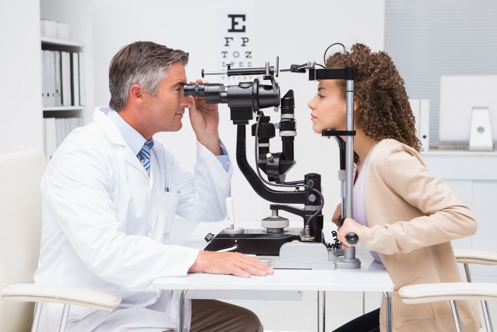 A Woman Is Getting Her Eyes Examined by An Ophthalmologist — New Look Eyewear In Maitland, NSW