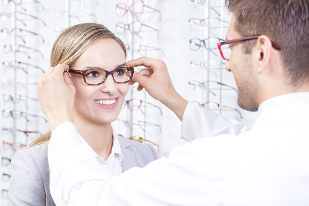 A Woman Is Getting Glasses from An Optician in An Optical Shop — New Look Eyewear In Maitland, NSW