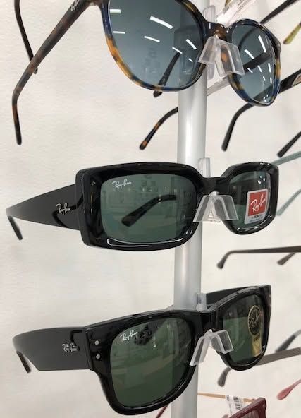A Bunch of Sunglasses Are Hanging on A Rack in A Store — New Look Eyewear In Maitland, NSW