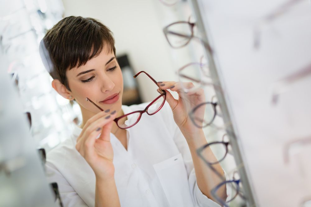 A Woman Is Trying on Glasses in An Optical Shop — New Look Eyewear In Maitland, NSW