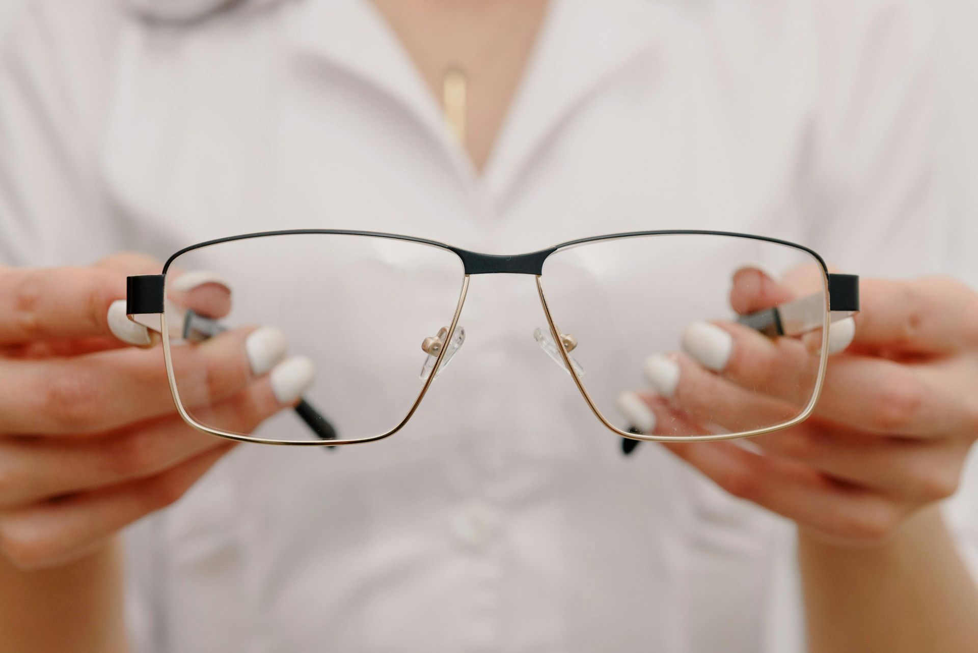 Person holding eyeglasses in both hands.— New Look Eyewear In Maitland, NSW