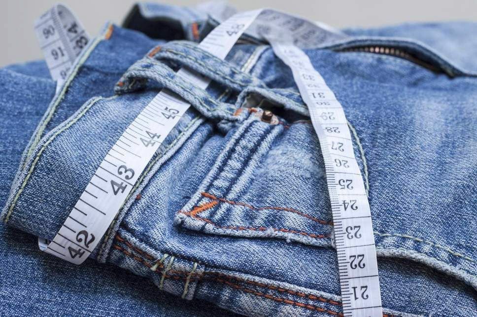Denim jeans with a measuring tape draped across them