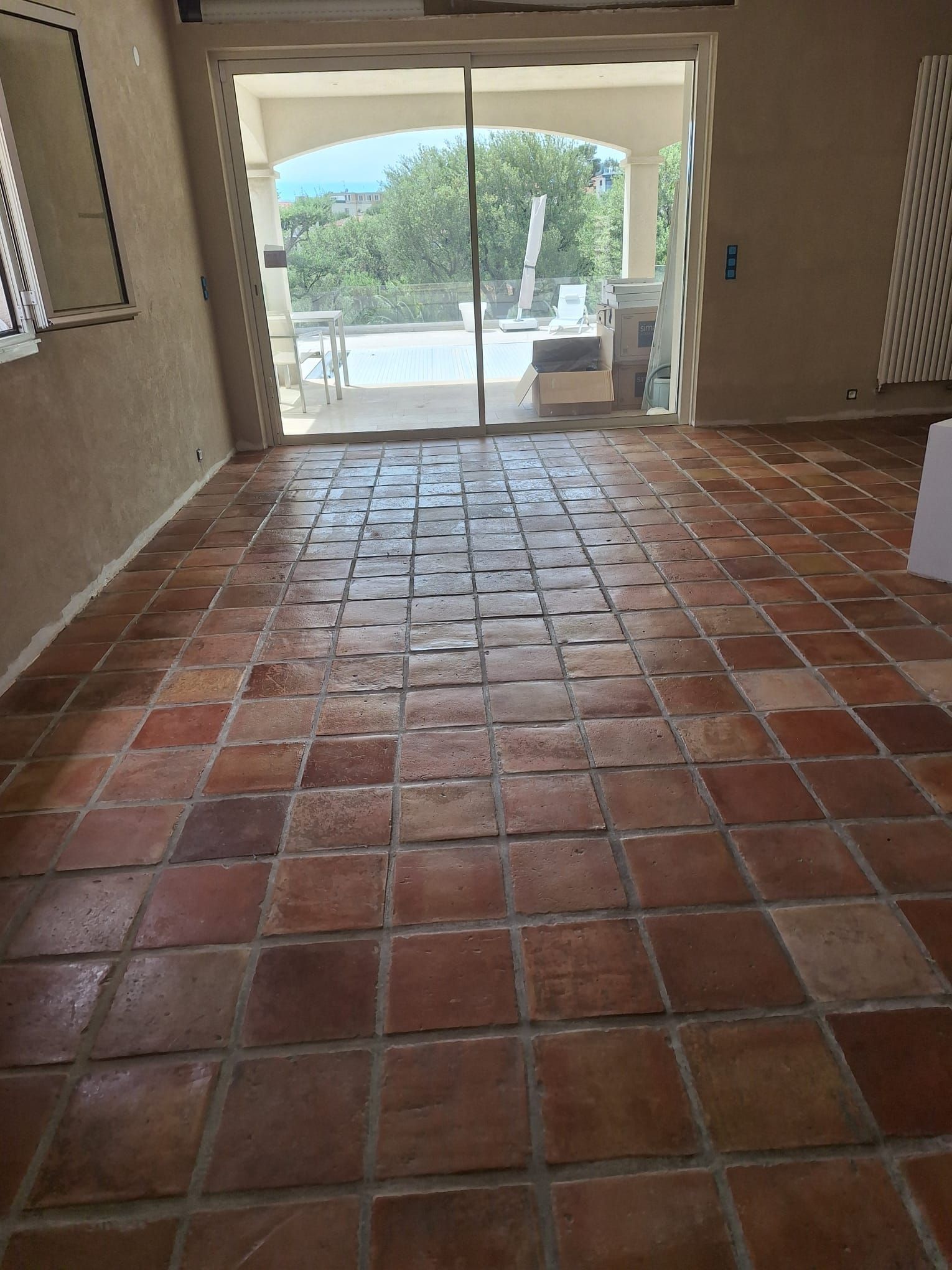 Pavimento in piastrelle di pietra marrone, esagonali, testurizzate, con fughe visibili.