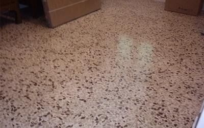 Pavimento color marrone chiaro con macchie marroni e scure, in una stanza.