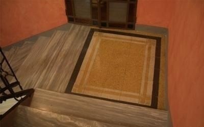 Scale in marmo con tappeto rettangolare giallo e marrone.