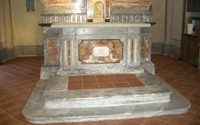 Altare in marmo con inserto in piastrelle e intagli religiosi.