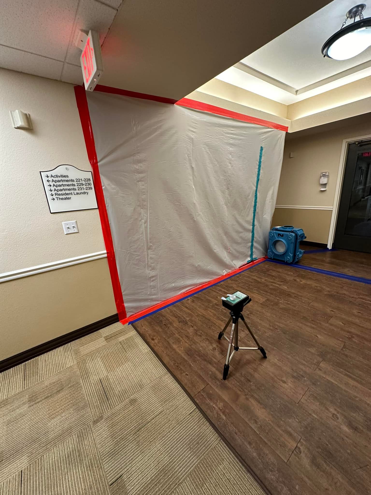 A room with a tarp on the wall and a camera on a tripod.