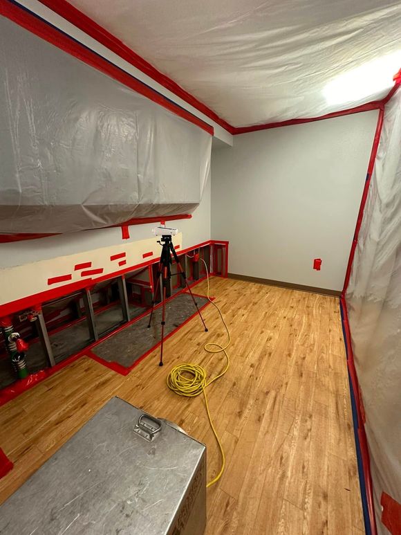 A room with a wooden floor and a camera on a tripod.